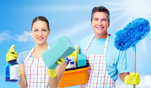 Cleaner wiping down shared corridor surfaces